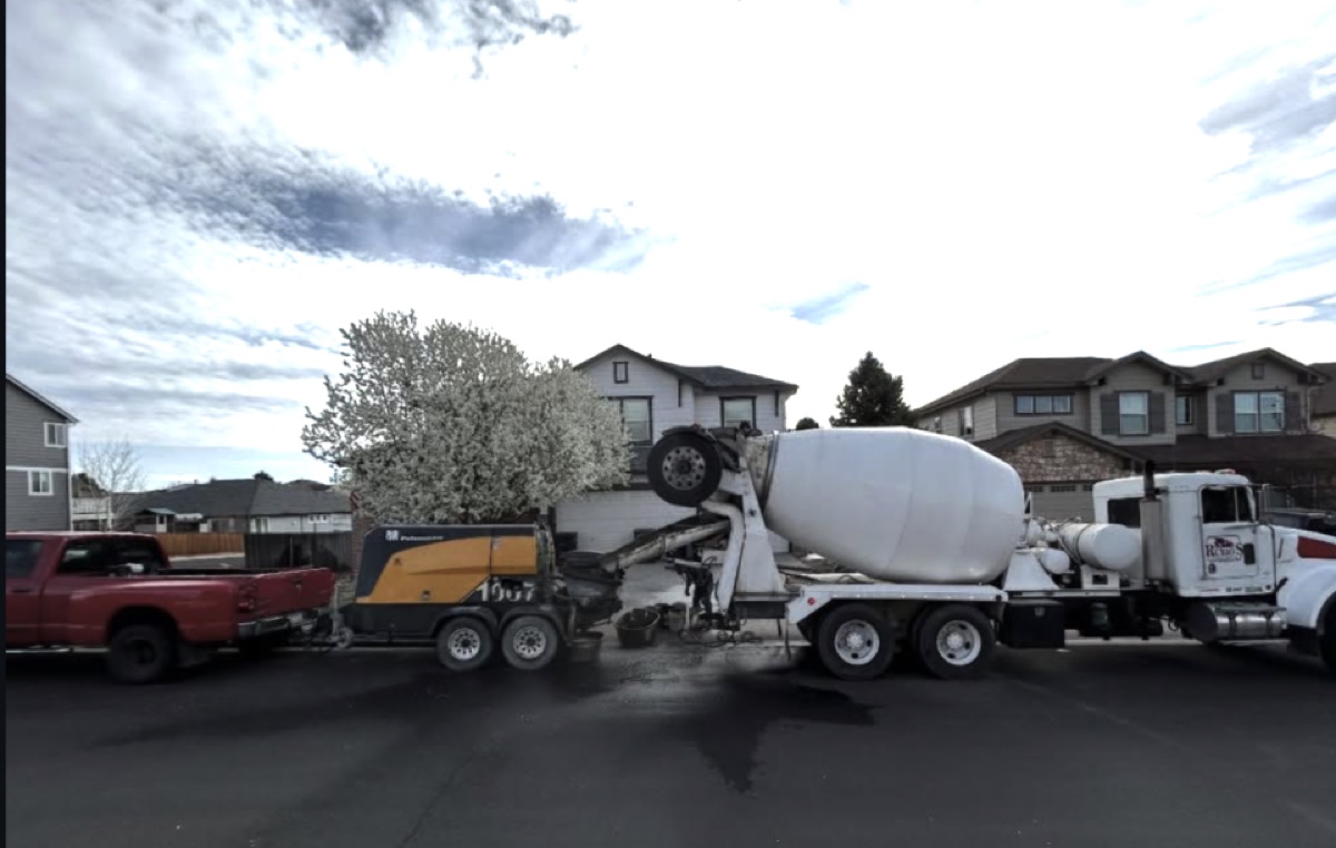 A Legacy Concrete mixer truck and pump on a residential street in Aurora